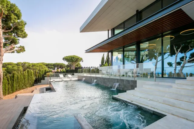 Villa ALTAMIRA, a Mediterranean home built in late 2021, sits atop the town of Caldes D’Estrac with spectacular views over the Maresme coast, just 500m from its beaches and 25 minutes from Barcelona city centre and cultural and academic hubs. This makes the property an permanent residence as well as a holiday home. Its architecture and interior design have been meticulously detailed, featuring a unique façade that sets it apart. The home offers numerous spacious rooms, floor-to-ceiling windows, and double-height ceilings that bring the Mediterranean lifestyle into every space. photo 13