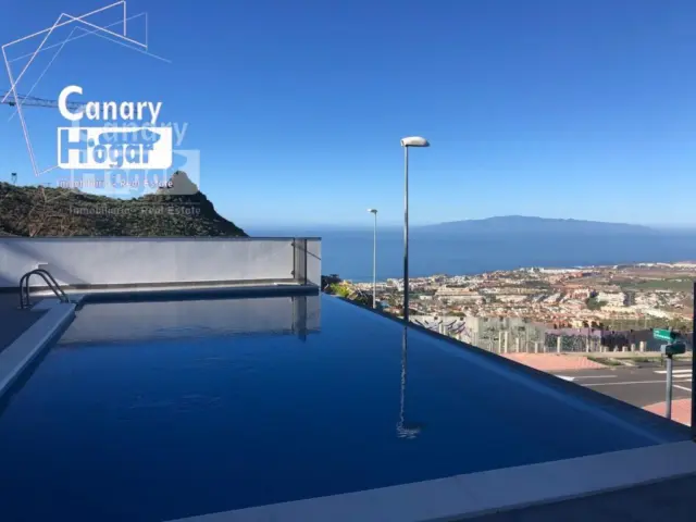 Villa to be newly built in Roque del Conde, featuring an elevator from the garage to the second floor. 230 m² of built area and a generous plot of 750 m². It comprises 4 bedrooms, 4 full bathrooms, with a layout that offers privacy and comfort. One bedroom on the ground floor can also serve as an office, while the three upper bedrooms enjoy panoramic views and private terraces capturing the stunning sunset... Enjoy the private infinity pool with sea and La Gomera views, where you can relax and create unforgettable moments. Equipped with air conditioning. Located just 15 minutes from Las Américas and 5 minutes from shopping centres, this property offers a privileged location combining tranquility and convenience. Perfect for those seeking an unfurnished home where they can unleash their creativity and personal style... Discover the luxury life awaiting you in Roque del Conde! Contact us for more details and to arrange a viewing of this impressive property.. #ref: - Canary Hogar Real
