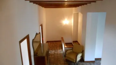 Townhouse for sale in the town centre of the peaceful village of Alcalalí. This corner property offers 350m2 of built space spread over three floors. The layout includes an entrance hall, living-dining room, fitted separate kitchen, five spacious bedrooms, two bathrooms, and a top floor loft with exposed wooden beams and external windows. The property is in good condition and retains its original design featuring high ceilings with wooden beams, clay tile floors, and both internal and external wooden joinery. It benefits from a rear patio and is within walking distance of all local amenities. photo 7