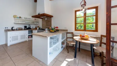 Luxury rural finca in one of Pollença’s most sought-after areas. Built in 2003, this property sits on a plot of 53,600m² with approximately 540m² of built space. The main house features a bedroom on the ground floor, a living room with a fireplace, a separate dining room, and a large kitchen with a pantry and laundry room, all overlooking the garden. Access to the garage, which can accommodate two large cars, is also on this level. photo 11