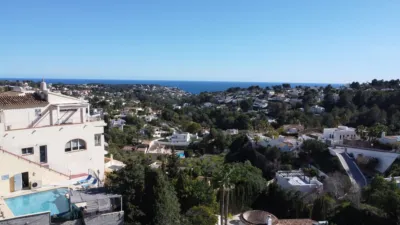 Luxury villa for sale in Benissa on a plot of 1,199 m². The property comprises 232.2 m² spread over three floors, featuring four bedrooms (two with en-suite bathrooms), three full bathrooms, a cloakroom and a modern kitchen. Key features include underfloor heating, air conditioning, double glazing and pre-installed lift. The outdoor space includes several terraces and a private swimming pool with sea views. Automatic gate entry with parking for multiple cars. Located close to local amenities and beaches. photo 7
