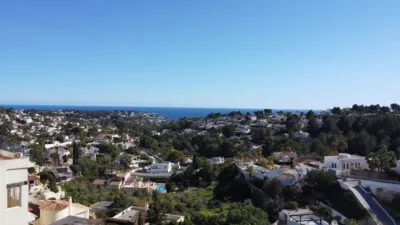 Luxury villa for sale in Benissa on a plot of 1,199 m². The property comprises 232.2 m² spread over three floors, featuring four bedrooms (two with en-suite bathrooms), three full bathrooms, a cloakroom and a modern kitchen. Key features include underfloor heating, air conditioning, double glazing and pre-installed lift. The outdoor space includes several terraces and a private swimming pool with sea views. Automatic gate entry with parking for multiple cars. Located close to local amenities and beaches. photo 4