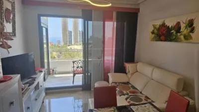 Loft for sale in Terramar Community, Benidorm. Located in Poniente, south-facing. €3,125/m². Opposite the Intempo building in Benidorm. Surrounded by green areas and a golf course. 2 bathrooms: 1 WC + 1 shower room. Walk-in closet. Fully equipped kitchen with high-quality Bosch appliances. The kitchen and dining area form a comfortable and cozy loft, complete with a leather sofa bed. Terrace with beautiful exterior views. Fully external apartment with plenty of natural light. Includes parking space. Storage room (2 × 2 m²). Elevator. Air conditioning-heating. 3 outdoor pools. 1 indoor heated pool. Full gym with showers. 4 WCs. 2 tennis-padel courts. Ping-pong table. Walking paths within the complex with benches. Alarm system installed. photo 2