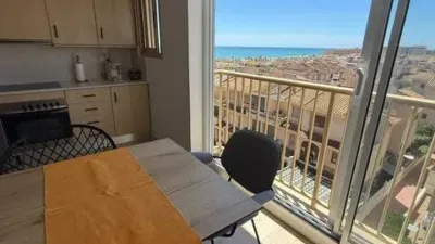 Duplex penthouse in Plaza Porticada, with 119 m² built area, 3 bedrooms, 2 bathrooms, good condition, floor 4, 2 wardrobes, 1 terrace(s), 25 m² of terrace, French kitchen, lift, 2006, green areas, 4 floors in the building, top floor, pets accepted. Duplex penthouse in Guardamar del Segura just 200m from the beach. The main floor features a living-dining room with side sea views, French kitchen, two bedrooms with fitted wardrobes, one bathroom. An internal staircase leads to the upper floor where there is a spacious bedroom with an en-suite bathroom and a private solarium of about 25m² with sea views. 119 m². There is also direct access to the communal solarium. In 2023, sold furnished and equipped. Close to all amenities. photo 5